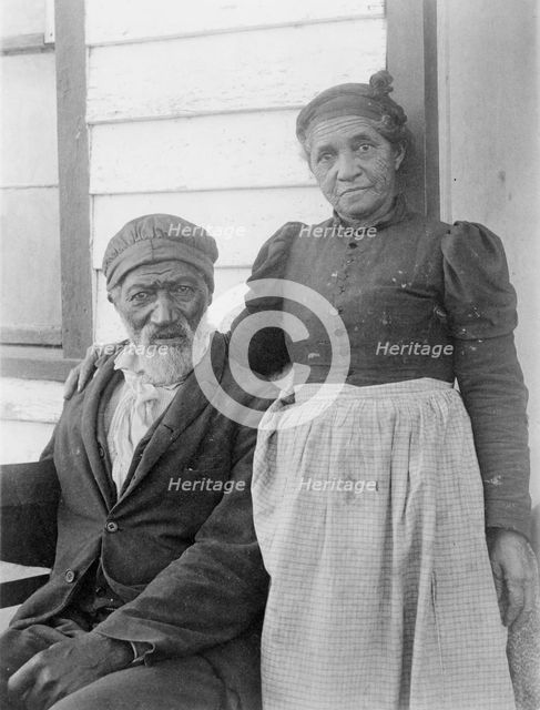 Elderly African American couple posed outside of building, near Hampton Institute..., 1899 or 1900. Creator: Frances Benjamin Johnston.