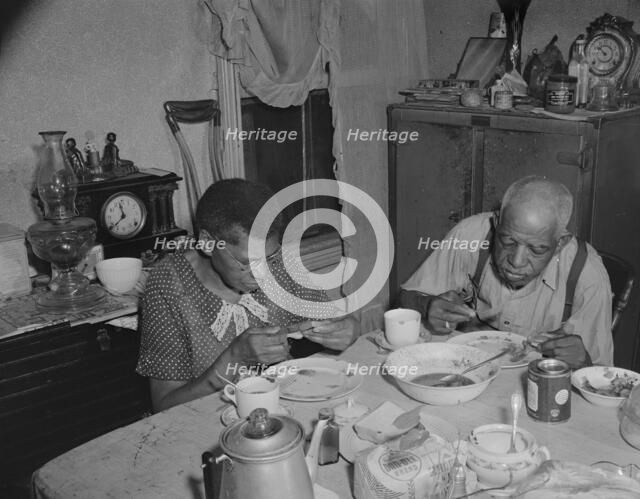 Elderly couple eating dinner at their home on Lamont Street, N.W., Washington, D.C., 1942. Creator: Gordon Parks.