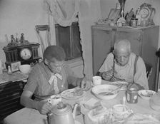 Elderly couple eating dinner at their home on Lamont Street, N.W., Washington, D.C., 1942. Creator: Gordon Parks