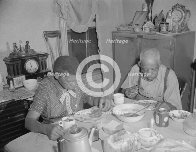 Elderly couple eating dinner at their home on Lamont Street, N.W., Washington, D.C., 1942. Creator: Gordon Parks.