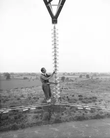 Electricity power insulator, cables and worker up a pylon, Nottinghamshire,c1950s-1960s(?). Creator: CEGB
