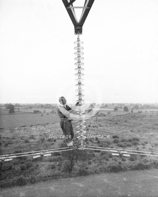 Electricity power insulator, cables and worker up a pylon, Nottinghamshire,c1950s-1960s(?). Artist: CEGB