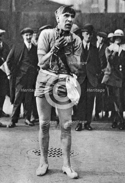 Escapologist entertaining theatre-goers in the 'pit' queue, London, 1926-1927. Artist: Unknown