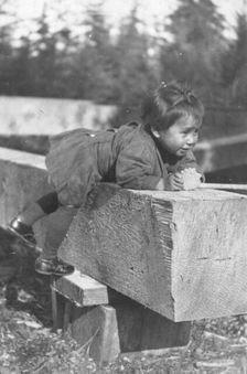 Eskimo child leaning on block of wood, 1905. Creator: Unknown