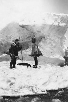 Eskimo with another man in winter scene, between c1900 and 1927. Creator: Lomen Brothers