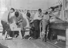 Eskimos doing carpenter work, between c1900 and c1930. Creator: Unknown