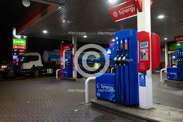 Esso petrol station forecourt with tanker delivering fuel, 2020. Creator: Tim Woodcock.