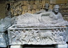 Etruscan stone sarcophagus with reliefs of Eastern influence, with a sculpture of a woman lying o…