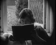 Evelyn Laye CBE, British Actress, Hiding Her Face Behind a Book, 1920. Creator: British Pathe Ltd