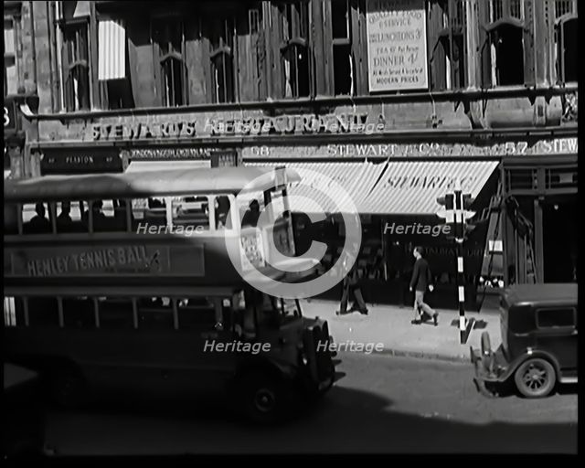 Exterior of Stewards Restaurant and London Traffic. Sign on the Side of a Bus Reads..., 1931. Creator: British Pathe Ltd.