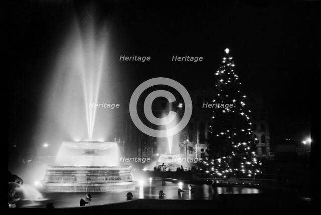 Fountains and the Christmas tree in Trafalgar Square, London, December 1948. Artist: Julian J Samuels.