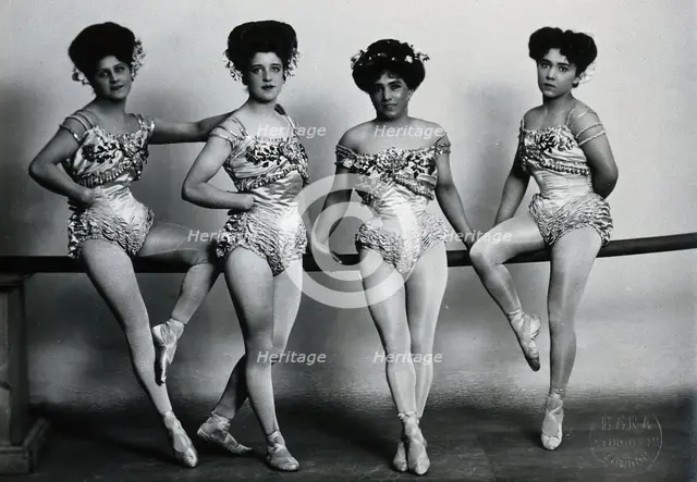Four young woman acrobats (?), posing on a bar in a photographic studio, between 1899 and 1908. Creator: Unknown.