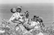 Four Eskimo children, at edge of cliff, in holiday costume, Nunivak, Alaska, c1929. Creator: Edward Sheriff Curtis