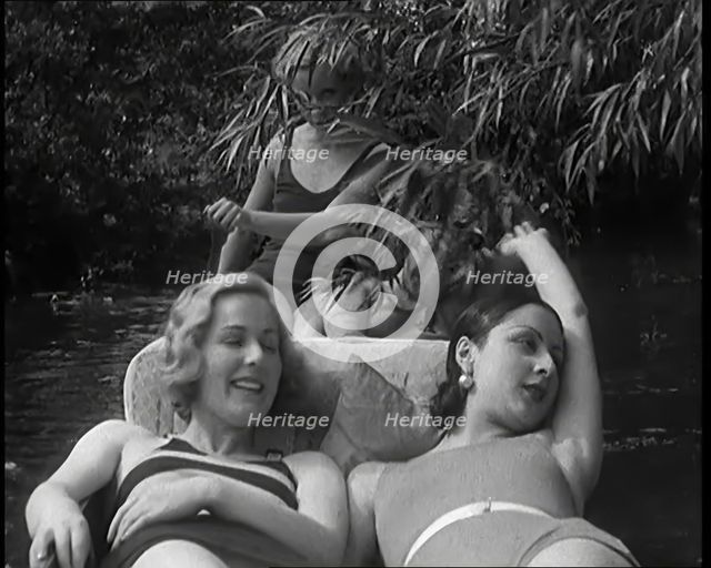 Four Female Civilians in Swimwear Riding Along the River in a Small Boat, 1931. Creator: British Pathe Ltd.