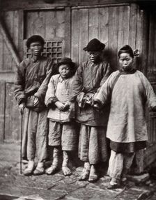 Foochow, China: four people with leprosy, wearing thick clothing, standing outside a wooden..., 1873 Creator: John Thomson