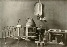 Foot-warmer; oil lamps; candle sconce; tin lantern; and toaster c18th century, (1937). Creator: Unknown