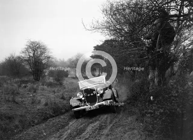 Ford V8 of H Hillcoat at the Sunbac Colmore Trial, near Winchcombe, Gloucestershire, 1934. Artist: Bill Brunell.