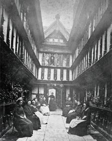 Ford's Hospital, Coventry: residents seated in the courtyard looking toward the street, c1880s. Creator: Unknown