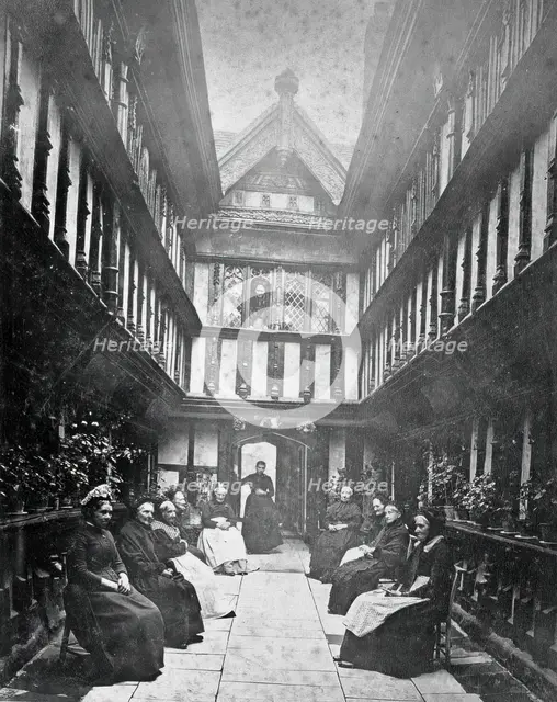 Ford's Hospital, Coventry: residents seated in the courtyard looking toward the street, c1880s. Creator: Unknown.