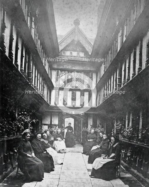 Ford's Hospital, Coventry: residents seated in the courtyard looking toward the street, c1880s. Creator: Unknown.