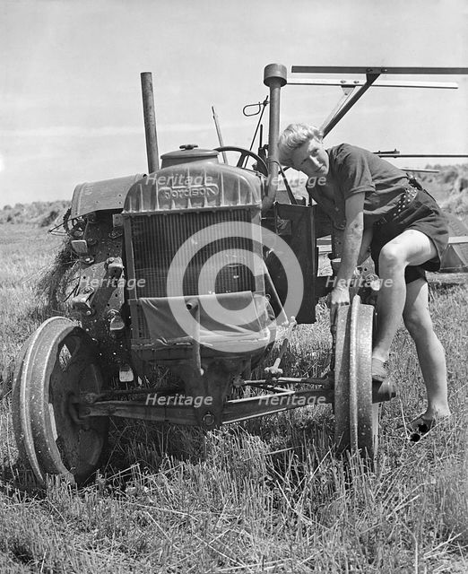 Fordson tractor, with Land girl 1940's. Creator: Unknown.
