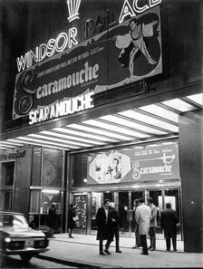 Façade of old cinema Windsor in Barcelona with neon signs advertising the film Scaromouche, 1952