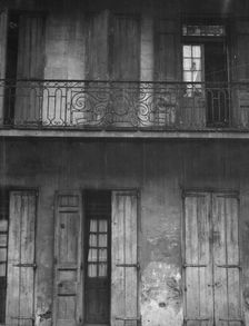 Facade of a building with shuttered doors and balcony, New Orleans or Charleston..., c1920-1926. Creator: Arnold Genthe