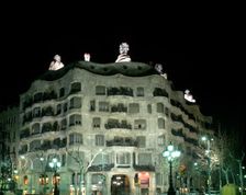 Façade of the Mila House or Pedrera lit at night, by Antoni Gaudí i Cornet (1852 - 1926)