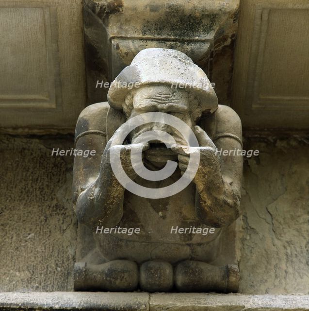 Façade of the Paeria of Cervera, anthropomorphic corbel of a personage sick of the teeth showing …