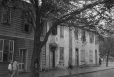 Facades of two-story houses, [Alexander Peronneau Tenements, 141 Church Street..., c1920-1926. Creator: Arnold Genthe