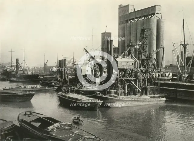 "Factories, Refineries, Granaries Grow Thick" Ship Discharging Grain by Floating Pneumatic...', 1937 Creator: J Dixon-Scott.