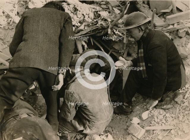 Family buried in a Morrison shelter after a raid, London, 1944. Artist: Unknown