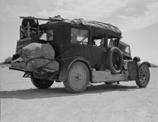 Family...from Fort Smith, Arkansas, trying to repair their car..., Arizona, 1937. Creator: Dorothea Lange