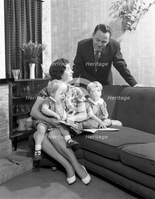 Family group looking at a brochure, Doncaster, South Yorkshire, 1963. Creator: Michael Walters.