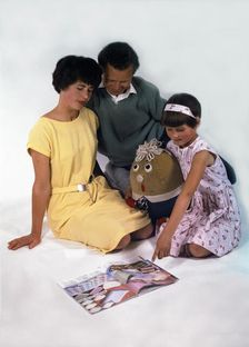 Family group looking at a magazine, 1963. Artist: Michael Walters