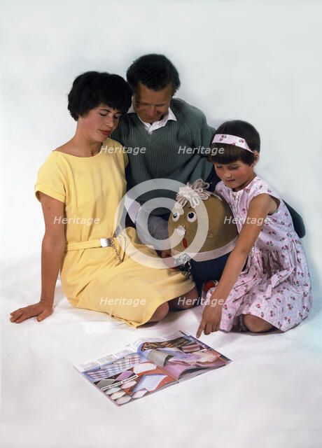 Family group looking at a magazine, 1963. Artist: Michael Walters