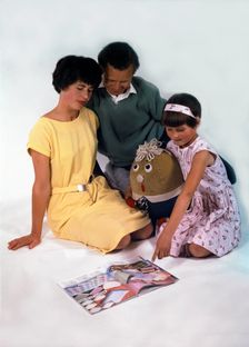 Family group looking at a magazine, 1963. Creator: Michael Walters