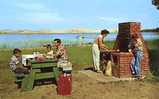 Family having a picnic on the beach by a lake, Michigan, USA, 1955