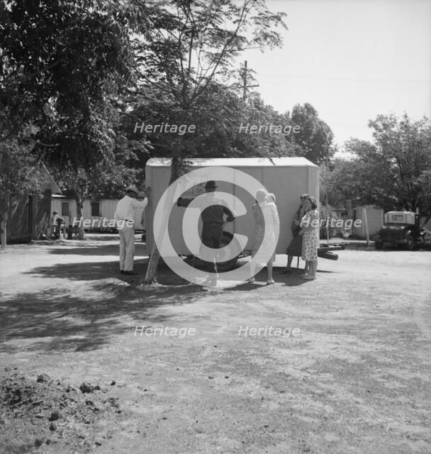 Family inspect a house trailer with idea of purchase, between Tulare and Fresno on U.S. 99, 1939. Creator: Dorothea Lange.