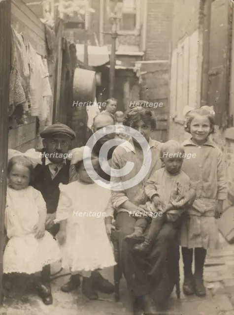 Family portrait in tenement alley, about 1913-1925. Creator: John Frank Keith.