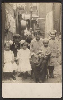 Family portrait in tenement alley, about 1913-1925. Creator: John Frank Keith