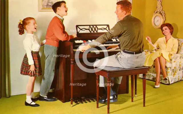 Family singing around a Wurlitizer organ as father plays, De Kalb, Illinois, USA, 1962. Artist: Unknown