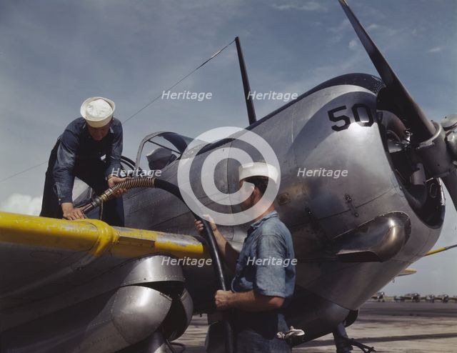 Feeding an SNC advanced training plane its essential supply of gas...Corpus Christi, Texas, 1942. Creator: Howard Hollem.