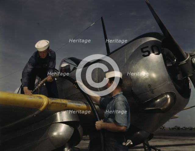 Feeding an SNC advanced training plane its essential supply of gas...Corpus Christi, Texas, 1942. Creator: Howard Hollem.