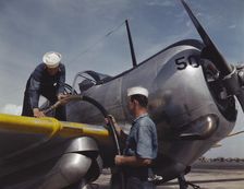 Feeding an SNC advanced training plane its essential supply of gas...Corpus Christi, Texas, 1942. Creator: Howard Hollem