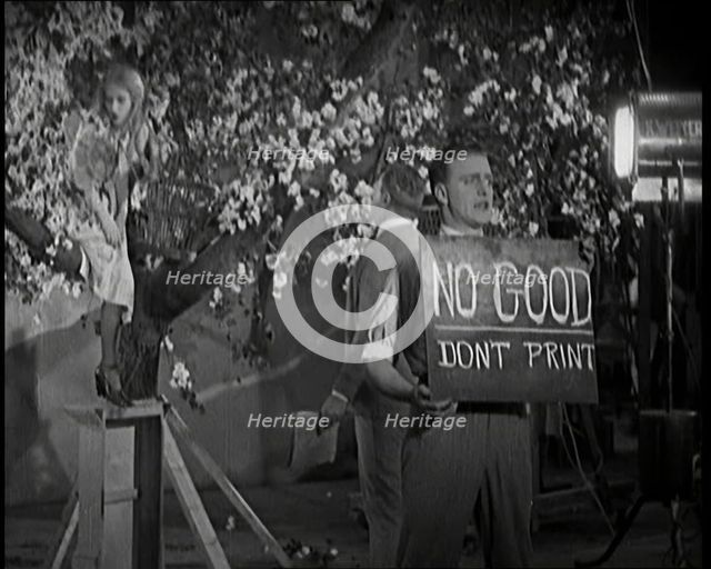 Female Actor Sitting in a Blossom Tree Whilst a Male Civilian Talks to Her..., 1920s. Creator: British Pathe Ltd.
