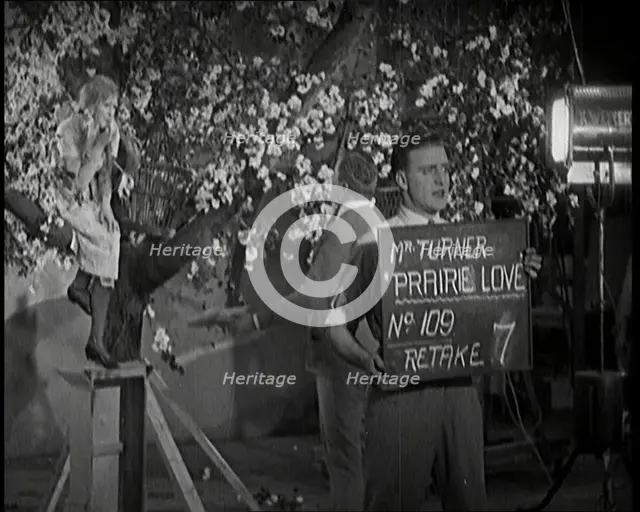 Female Actor Sitting in a Blossom Tree Whilst a Male Civilian Talks to Her..., 1920s. Creator: British Pathe Ltd.