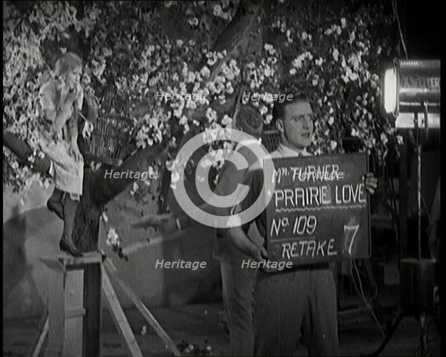 Female Actor Sitting in a Blossom Tree Whilst a Male Civilian Talks to Her..., 1920s. Creator: British Pathe Ltd.