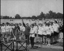 Female British Olympic Athletes Doing the Olympic Salute at the Women's World Games, 1922. Creator: British Pathe Ltd