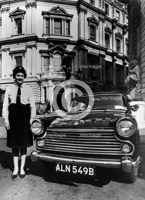 Female chauffeur standing by a 1964 Morris Oxford, 1964. Artist: Unknown